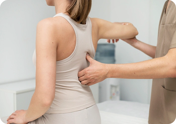 Physiotherapist performing a back adjustment on a patient