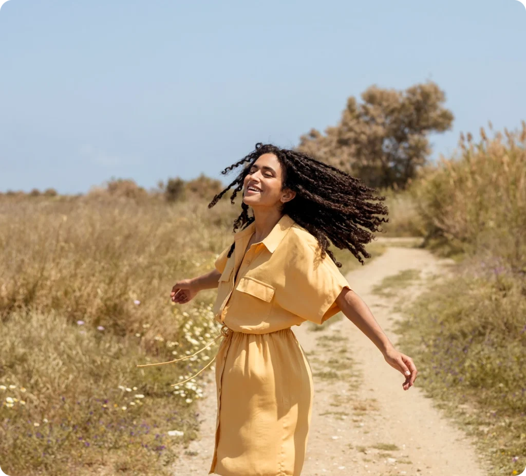 Carefree woman in a yellow dress outdoors